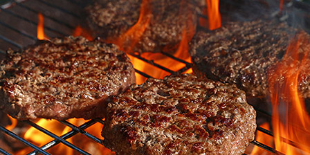 burgers sizzling on a grill